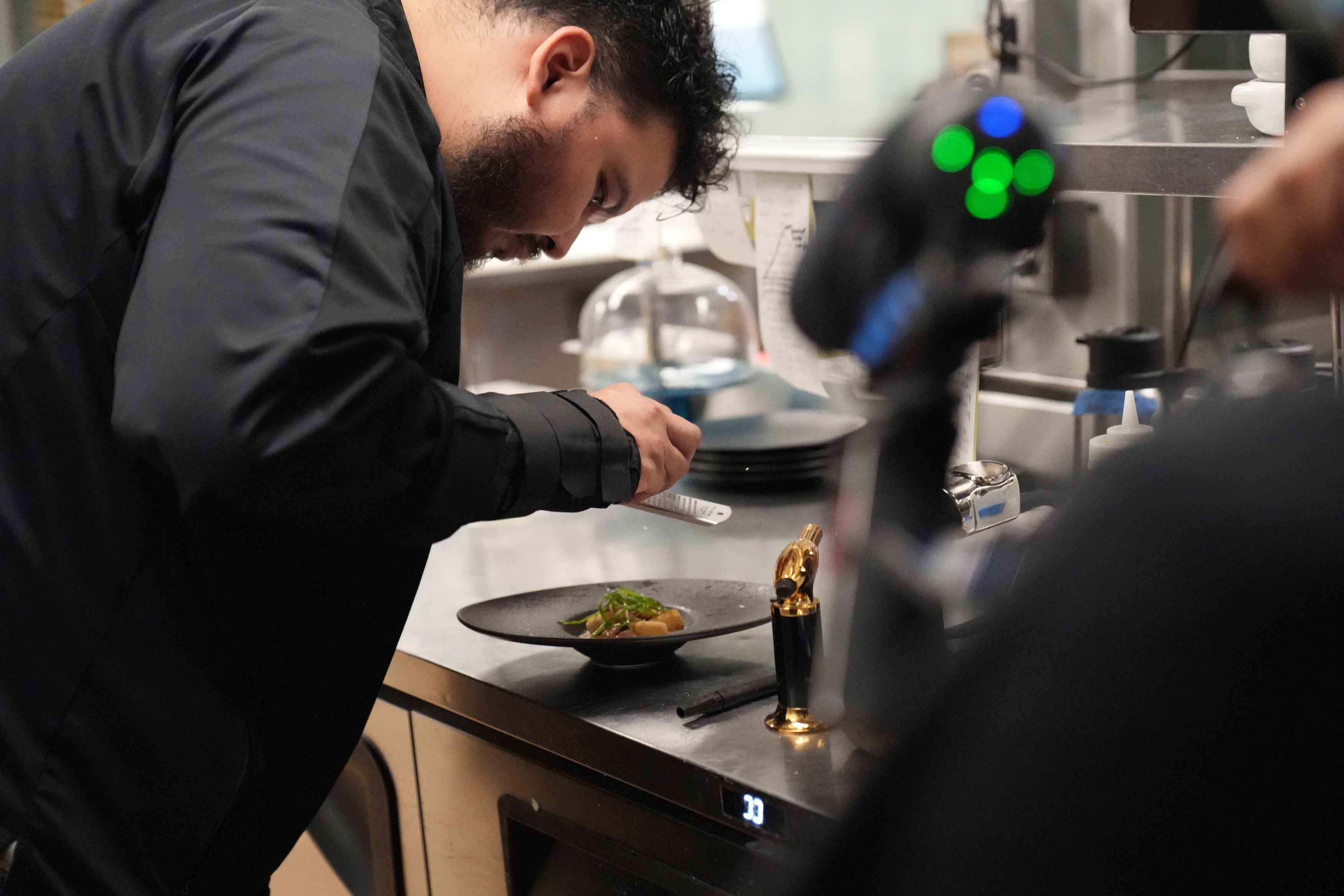 A Foodbox camera filming a chef as he plates a dish at Braseria