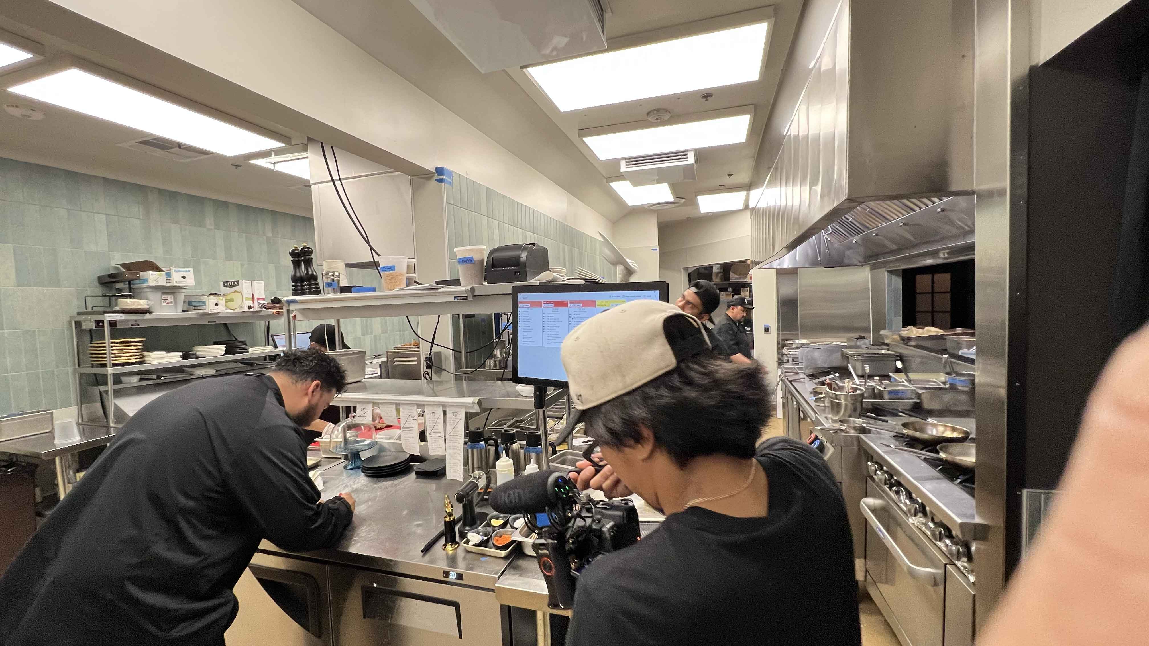 A Foodbox camera filming a chef at the Braseria kitchen pass during service