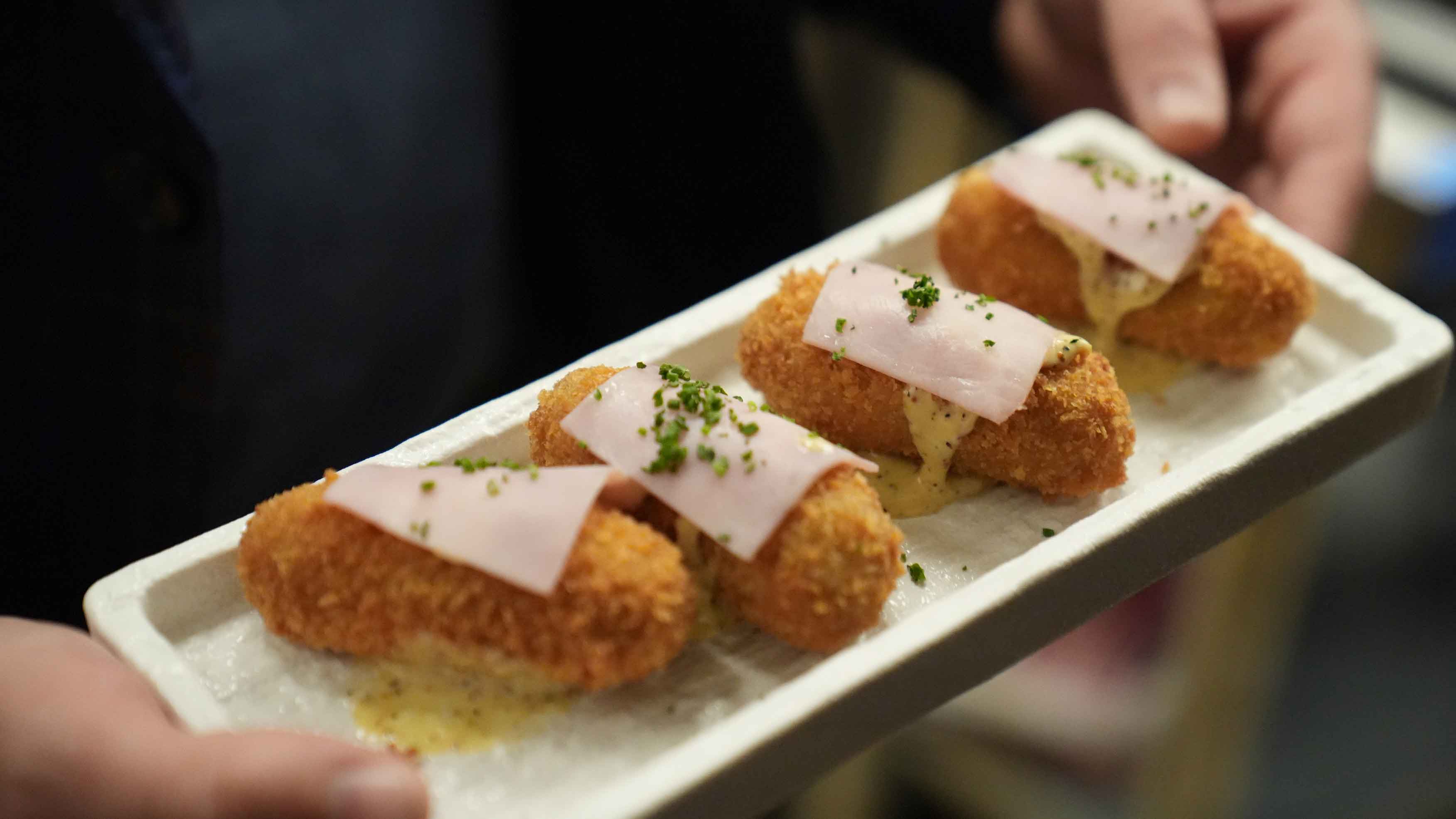 A plated Braseria dish being carried during service