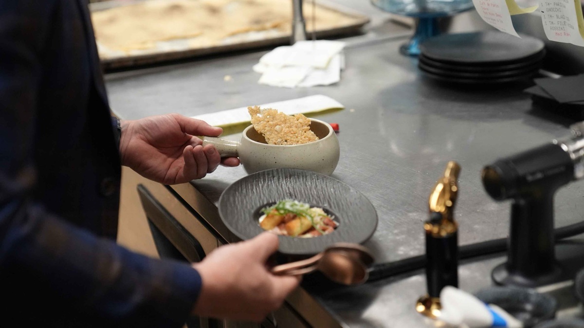 A plate being finished at the pass in the Braseria by EDO kitchen.